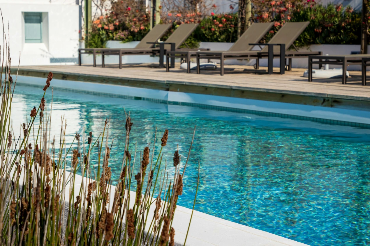 A swimming pool with lounge chairs next to it
